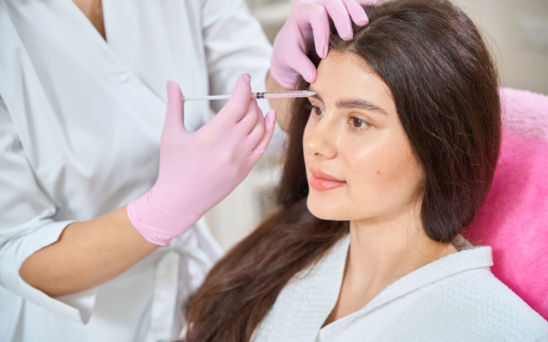 women sitting in chair getting cosmetic filler injectible